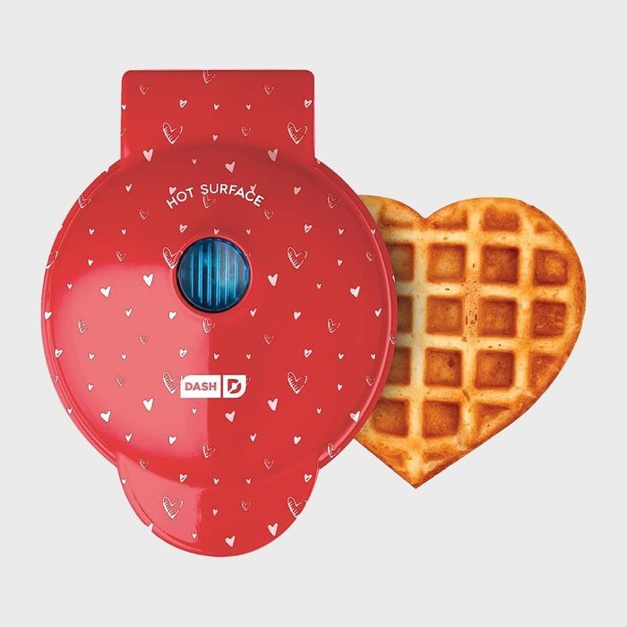 A red waffle maker with heart pattern and 