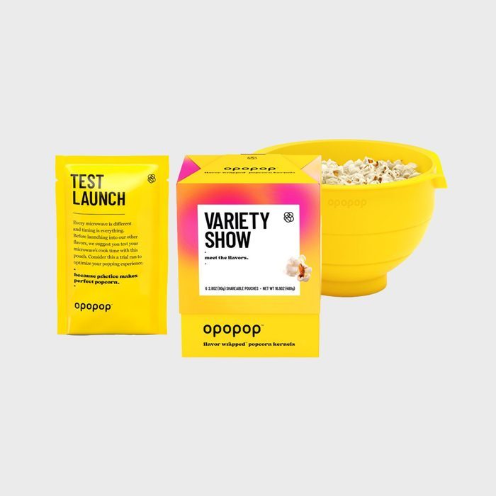 Yellow packaging surrounds popcorn kernels beside a filled yellow popcorn bowl. Labels read 