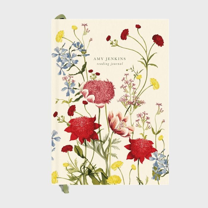 Journal features colorful flowers on cover, resting against a light background. Text reads 
