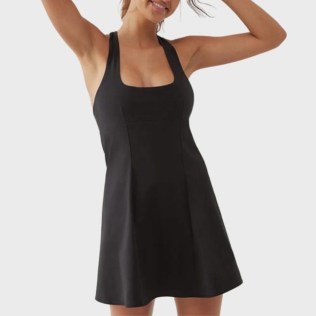 Sleeveless black dress worn by a person standing with hands raised, set against a plain white background.