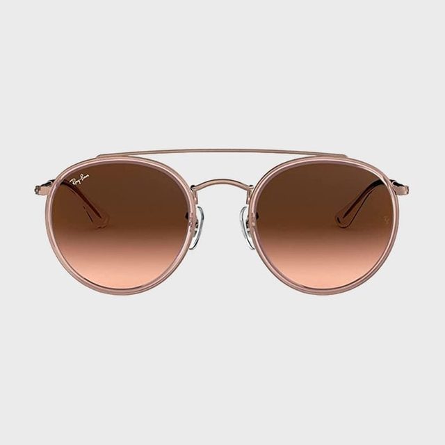 Sunglasses feature brown round lenses with a thin metal frame, displayed against a plain background.