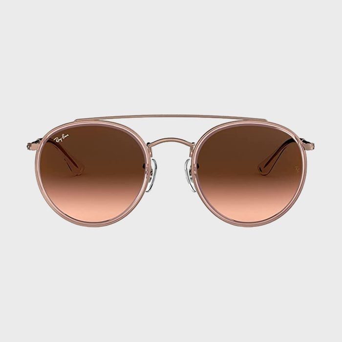 Sunglasses feature brown round lenses with a thin metal frame, displayed against a plain background.