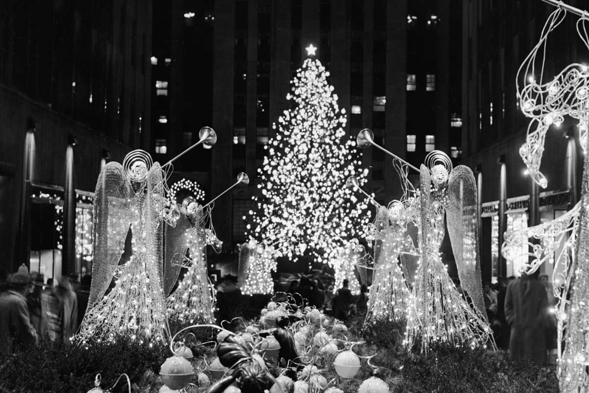 A Christmas tree and illuminated trumpeting angels adorn Rockefeller Plaza, New York, New York, circa 1950s. (Photo by Lawrence D. Thornton/Frederic Lewis/Getty Images)