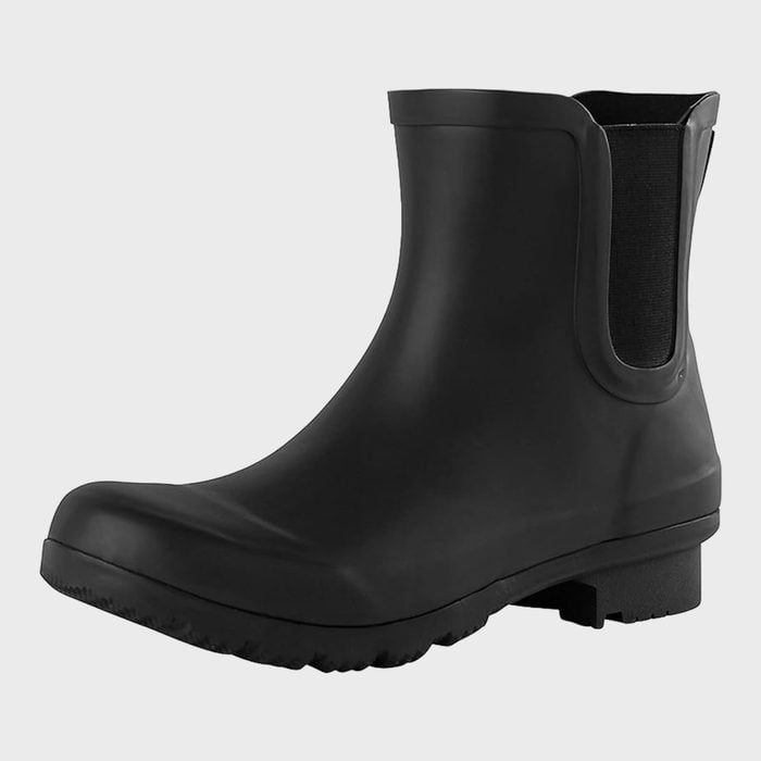 A black rubber ankle boot rests on a plain background, featuring an elastic side panel and textured sole for grip.