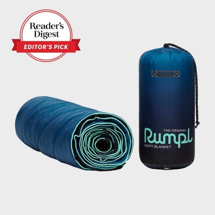 Rolled blue blanket sits next to its compact carrying case; 
