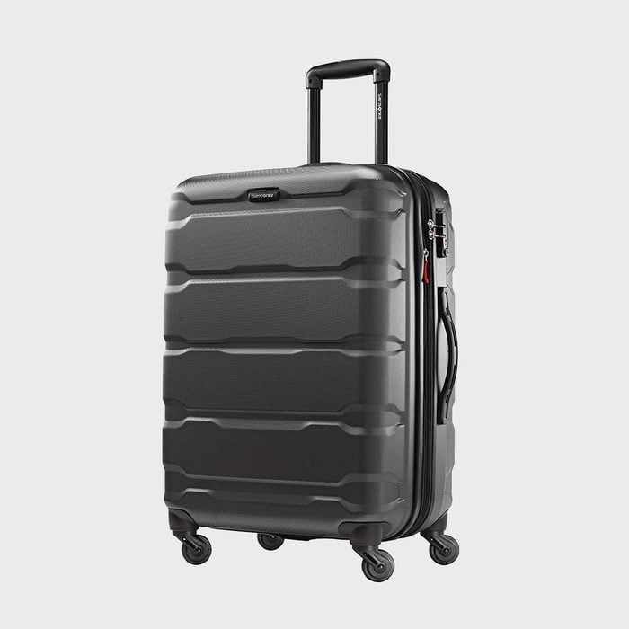 A black hard-shell suitcase, standing upright, features a telescopic handle and four spinning wheels against a plain, neutral background.