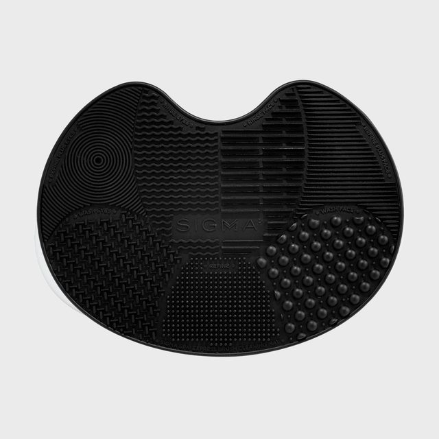 Black textured mat features varied patterns labeled for brush cleaning functions, with 