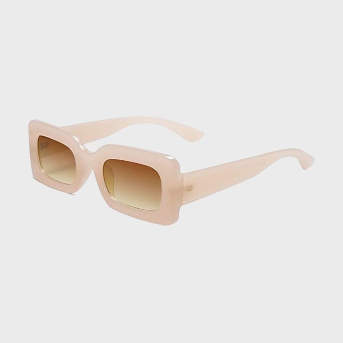 Sunglasses sit with beige rectangular frames and gradient lenses against a plain white background.