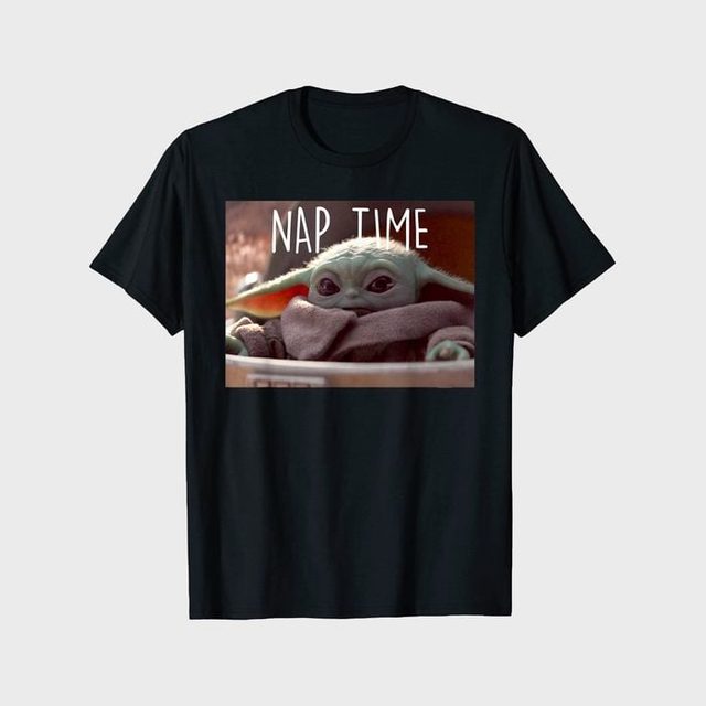 T-shirt displays a small green character bundled in a blanket, with text 