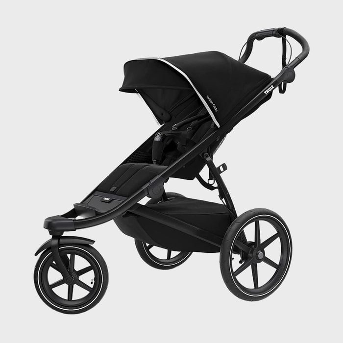 A black stroller stands with three large wheels, featuring a canopy and labeled 