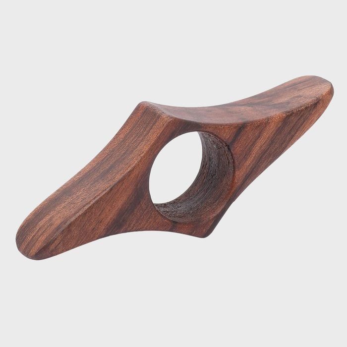 Wooden object featuring a central hole, possibly a handle or tool, displayed against a plain background.