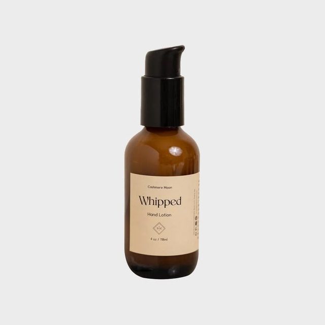 Brown bottle stands upright, dispensing hand lotion, labeled 