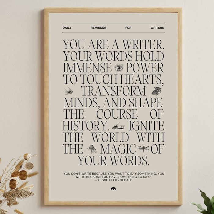 Framed poster displays motivational text for writers, emphasizing the power of words to influence hearts, minds, and history. Decorative illustrations accompany the words.