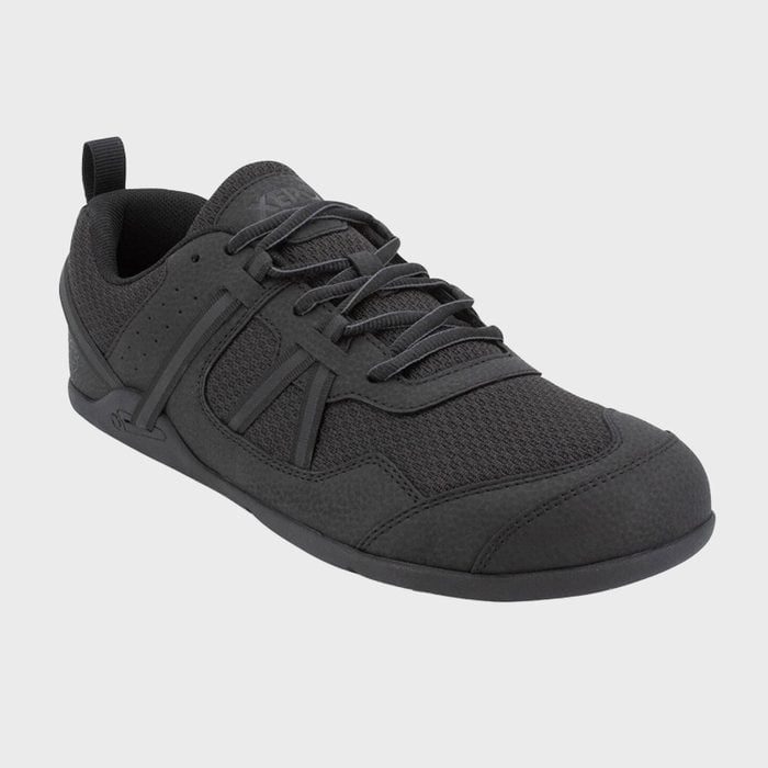 A black athletic shoe with laces sits on a plain gray background.