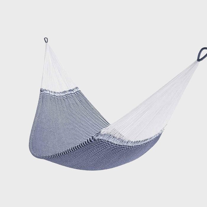 A blue and white striped hammock hangs in suspension against a plain light gray background.