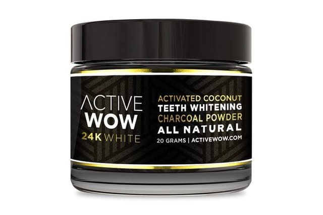 A jar containing activated coconut charcoal powder sits against a plain background. Label reads: 