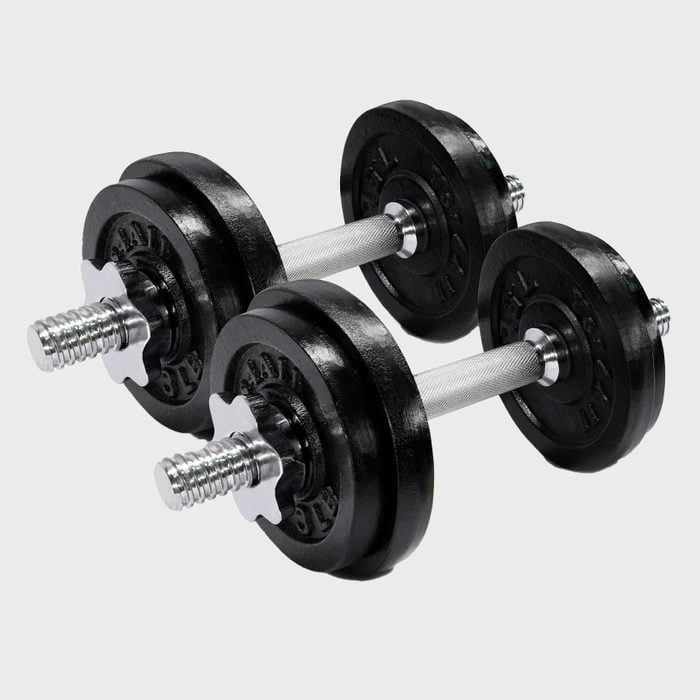 Two black dumbbells resting on a gray surface, with visible metallic handles and weight plates on each end.
