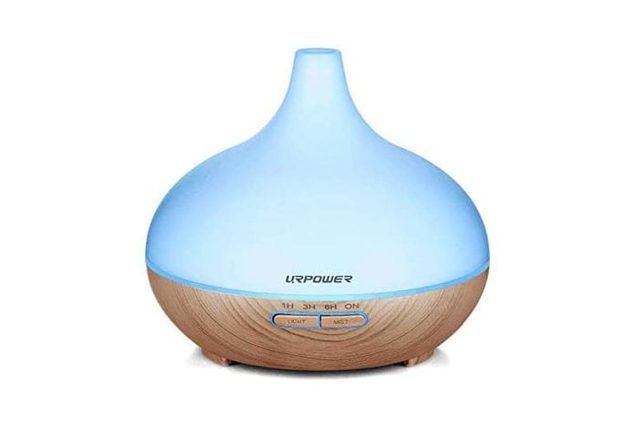 A round, blue and wood-textured diffuser releases mist, placed on a white background. Text reads 