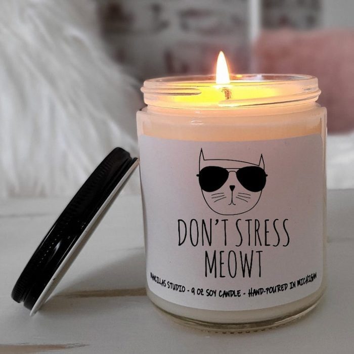 Candle burns warmly in a jar labeled 