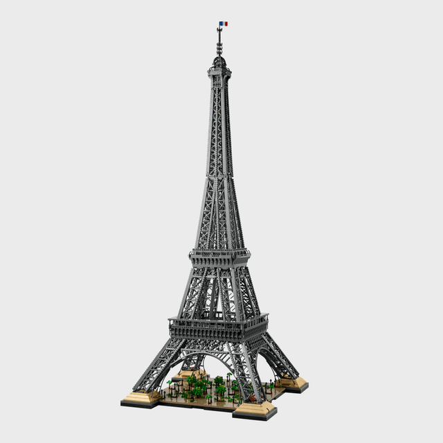 LEGO Eiffel Tower model stands assembled, featuring intricate details and a small French flag, set against a plain white background.