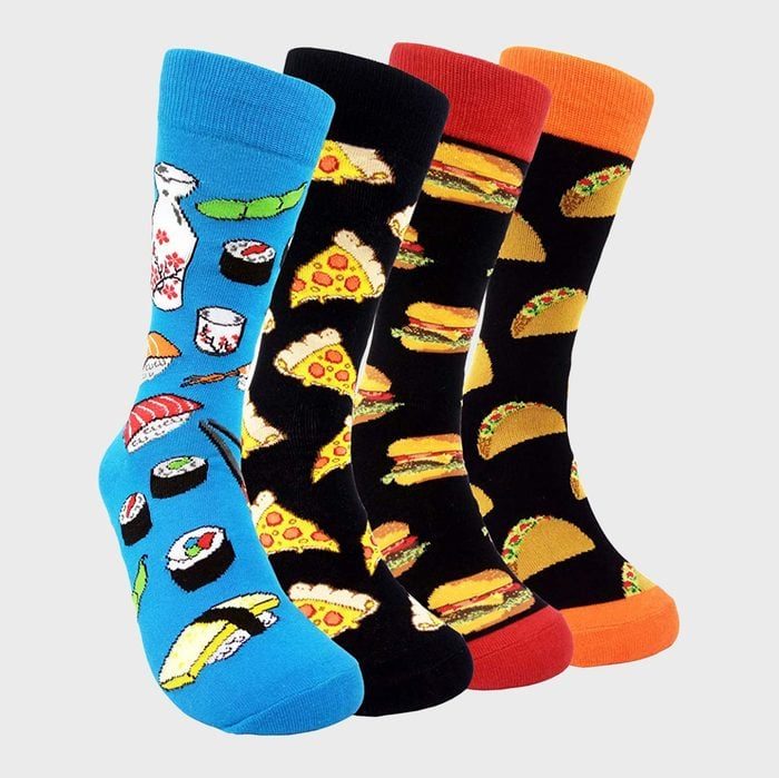 Socks feature vibrant food patternsâ€”sushi on blue, pizza on black, burgers on red, tacos on orangeâ€”standing upright against a neutral background.