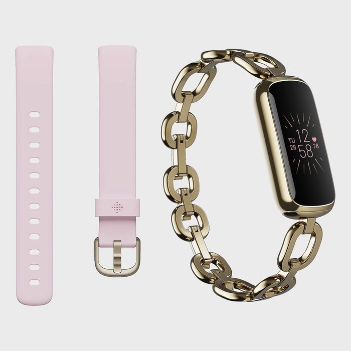 Smartwatch displays time and health metrics, featuring a gold chain band next to an alternative pink silicone strap on a plain background.