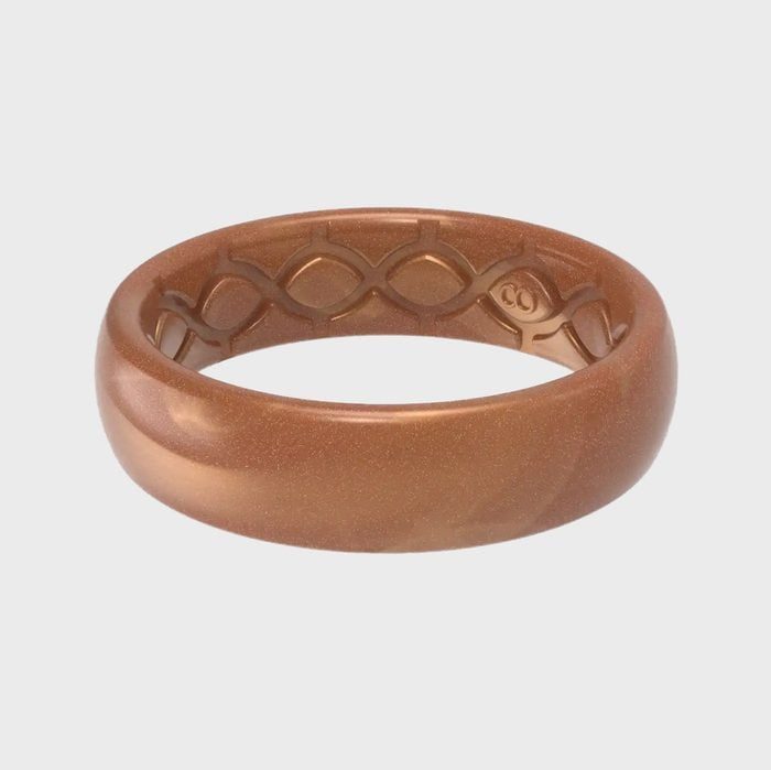 Copper-colored ring rests on a light gray background, featuring an inner wave pattern for texture.