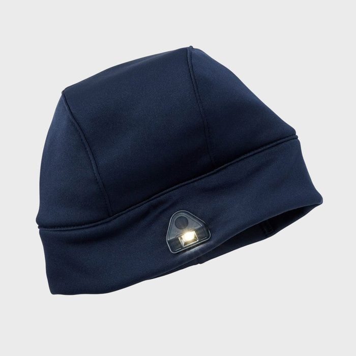 A dark blue beanie with an LED light embedded in the front, set against a plain gray background.