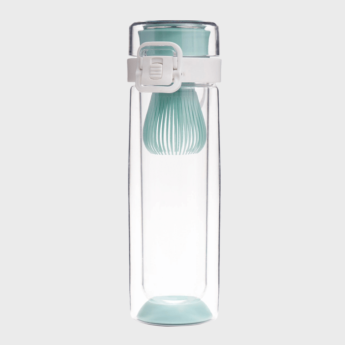 A clear bottle with a teal filter sits upright; its white latch secures the lid; set against a plain background.