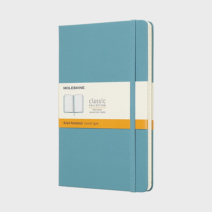 A blue notebook remains closed with an elastic band, labeled 