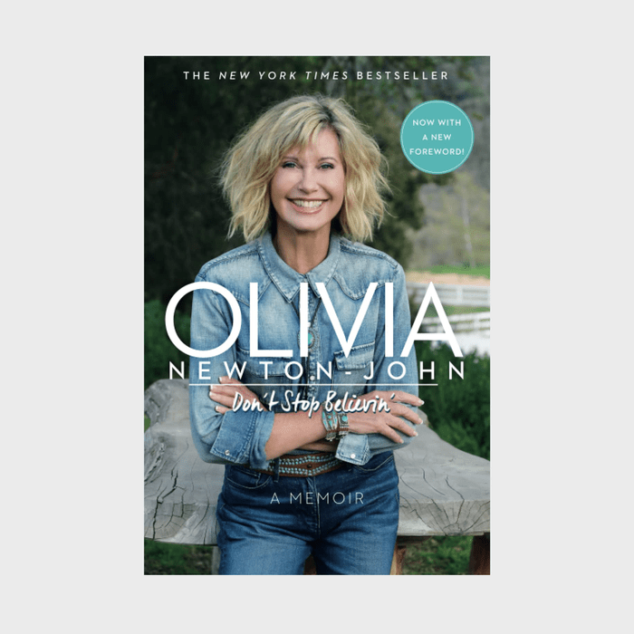 Smiling woman in denim sits on a wooden bench. Book title: 