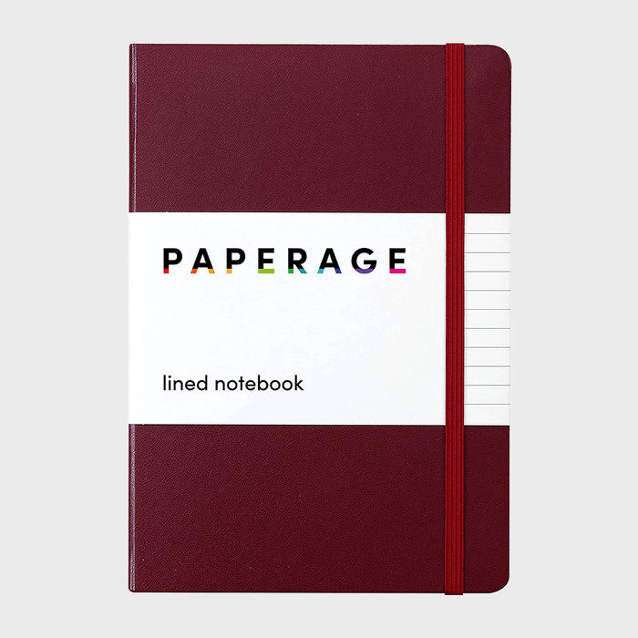 A burgundy notebook sits upright with an elastic band, labeled 