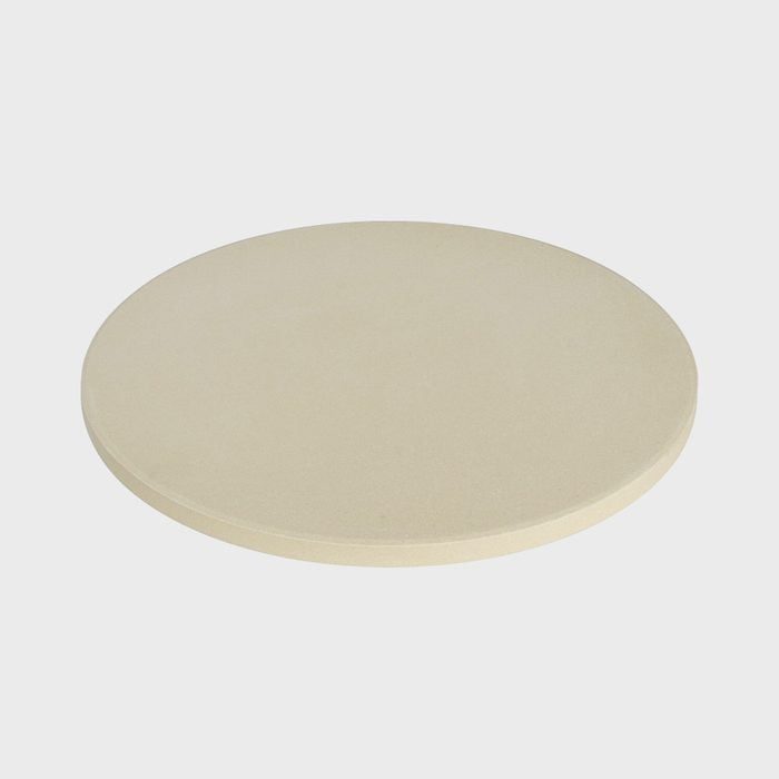 Round, beige stone sits stationary against a plain white background, appearing smooth and slightly raised.