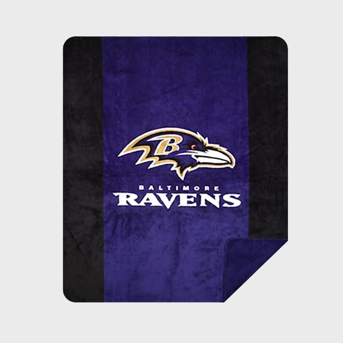 A blanket features a purple-and-black design with a raven logo and 