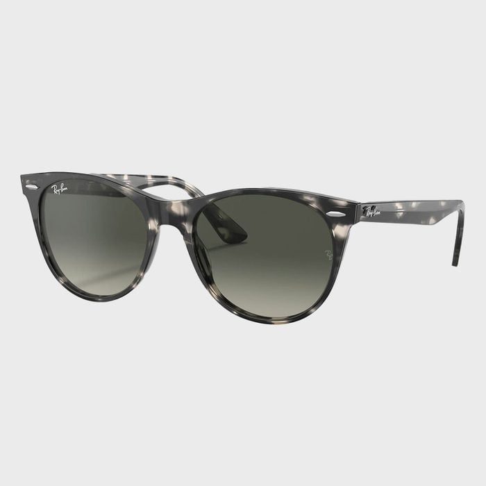 Sunglasses resting on a light gray background; featuring a gray tortoiseshell frame and dark lenses with 