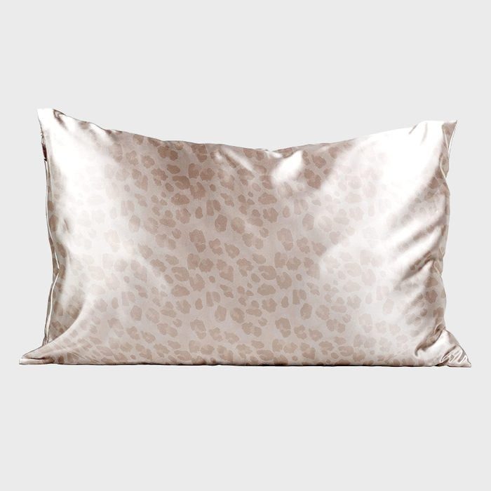 Silk pillowcase displays subtle leopard pattern, resting on a plain, light gray background.