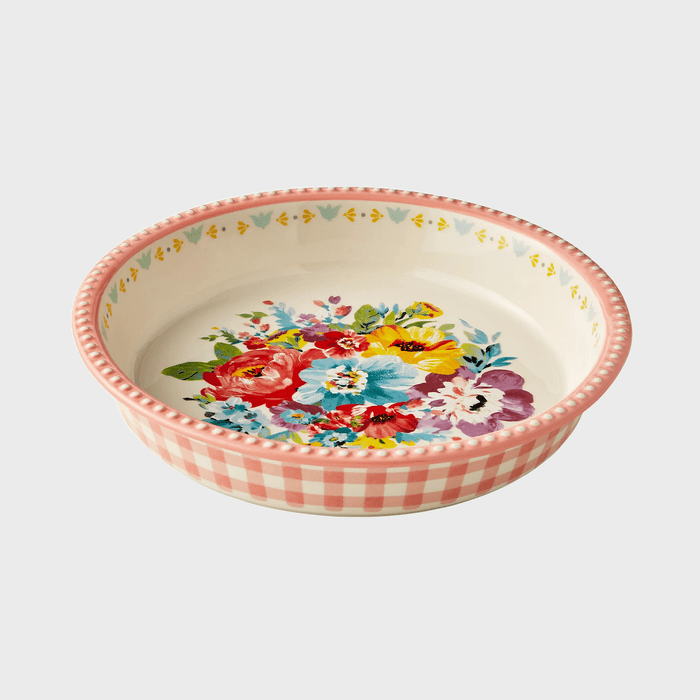 A ceramic bowl displays colorful floral patterns, surrounded by a pink gingham border, set against a light background.