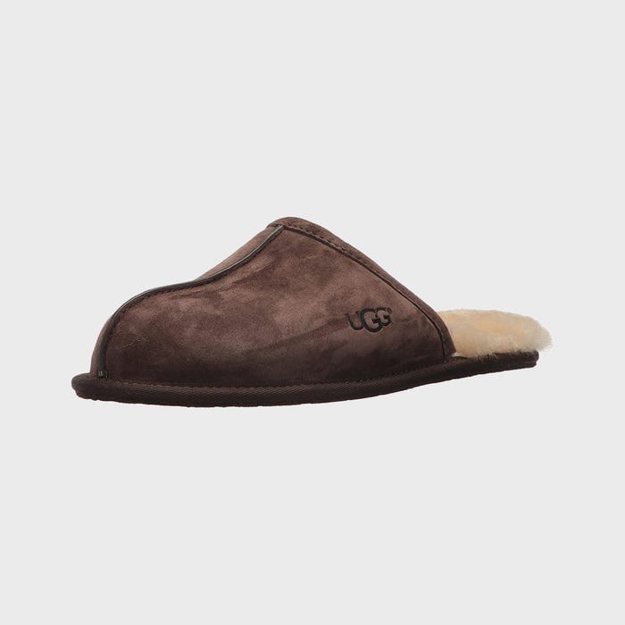 Brown slipper lies on a plain background, displaying the brand logo on the side and a fluffy interior.
