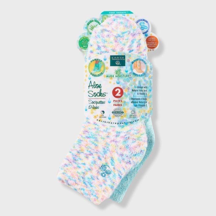 Colorful, fuzzy socks packaged, displaying label for two aloe-infused pairs. Promotes moisture, comfort with pastel patterning. Background is plain and neutral.