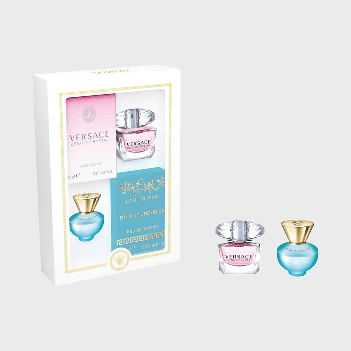 Two miniature Versace perfume bottles displayed beside a white box packaging. The box features branding and product details in pink and blue sections.