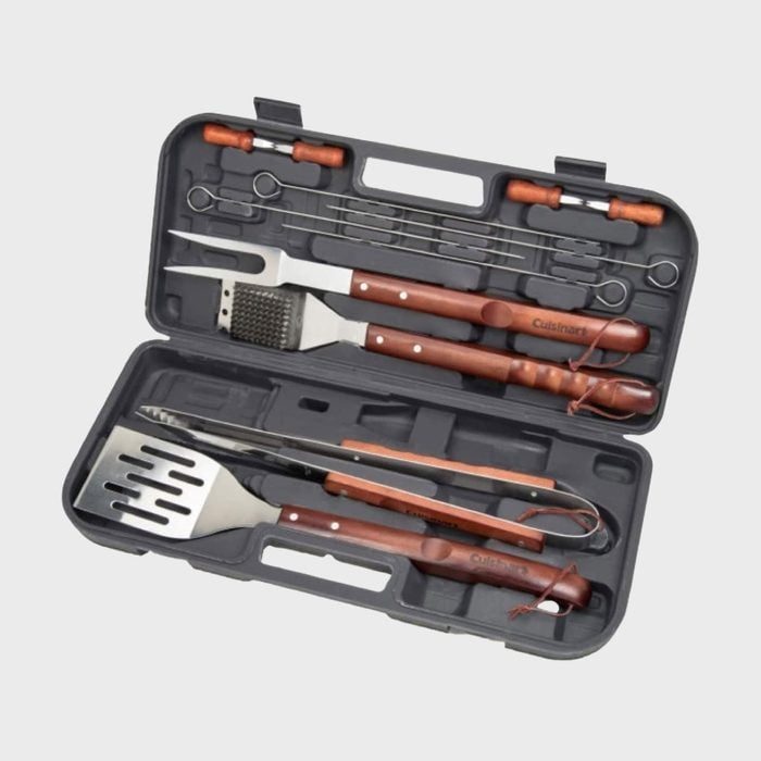 Barbecue utensil set arranged in an open plastic case, featuring skewers, spatula, fork, and tongs with wooden handles in a gray molded interior.