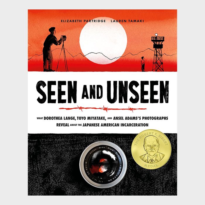 Cover features silhouetted photographers and watchtower against a red sun, highlighting the title 