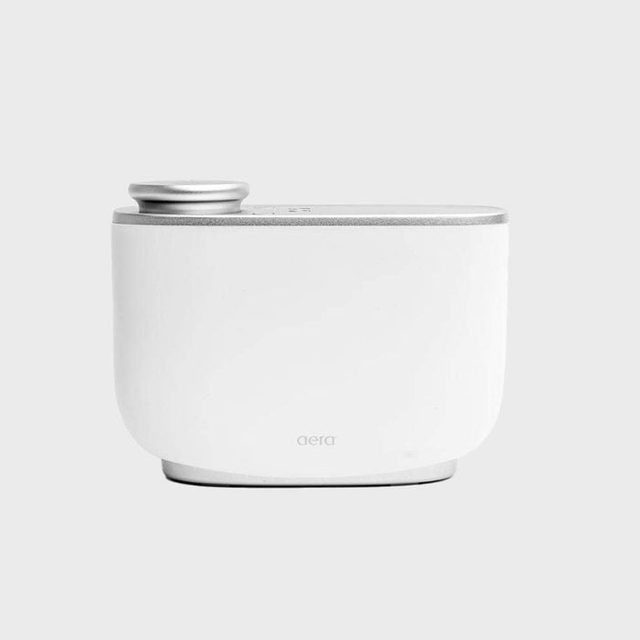 White scent diffuser resting on a surface, designed for home use, marked 