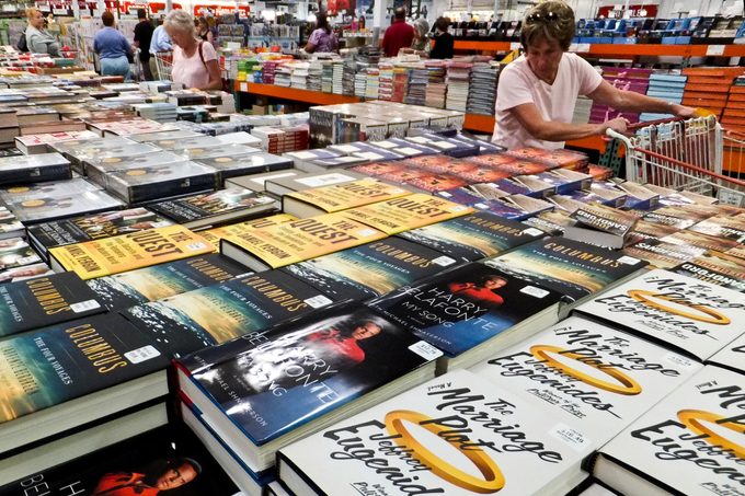 A Woman Shops at a table of books at Costco, Which Will Soon Stop Selling Books