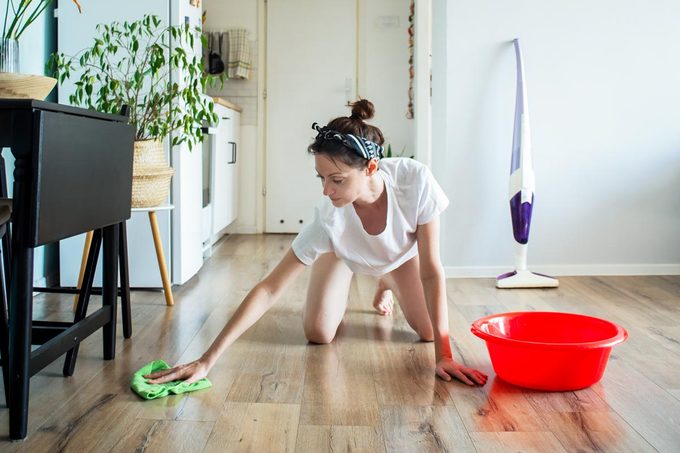 Common Mistake Can Ruin Your Floors This Winter - woman cleaning wooden floor