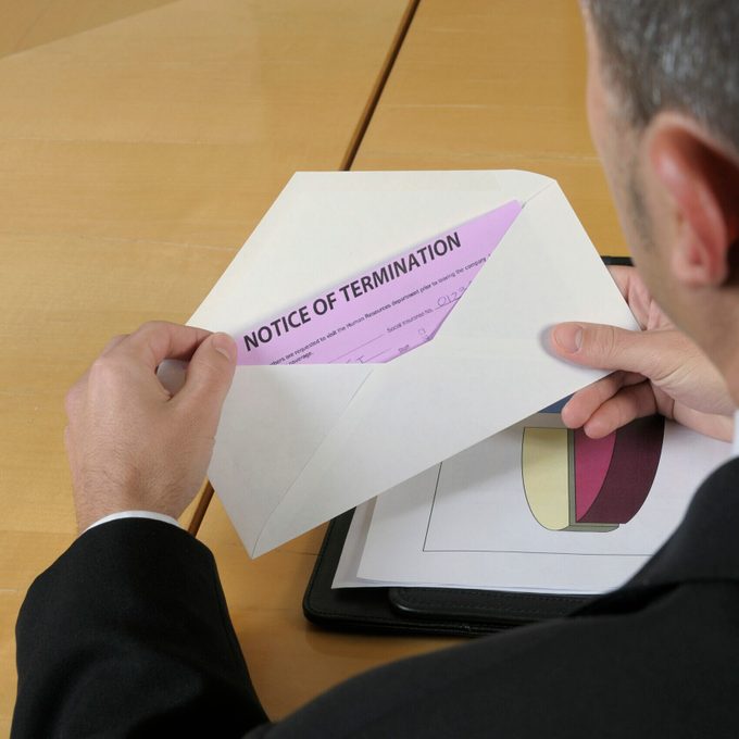 Man opening an envelope containing pink notice of termination