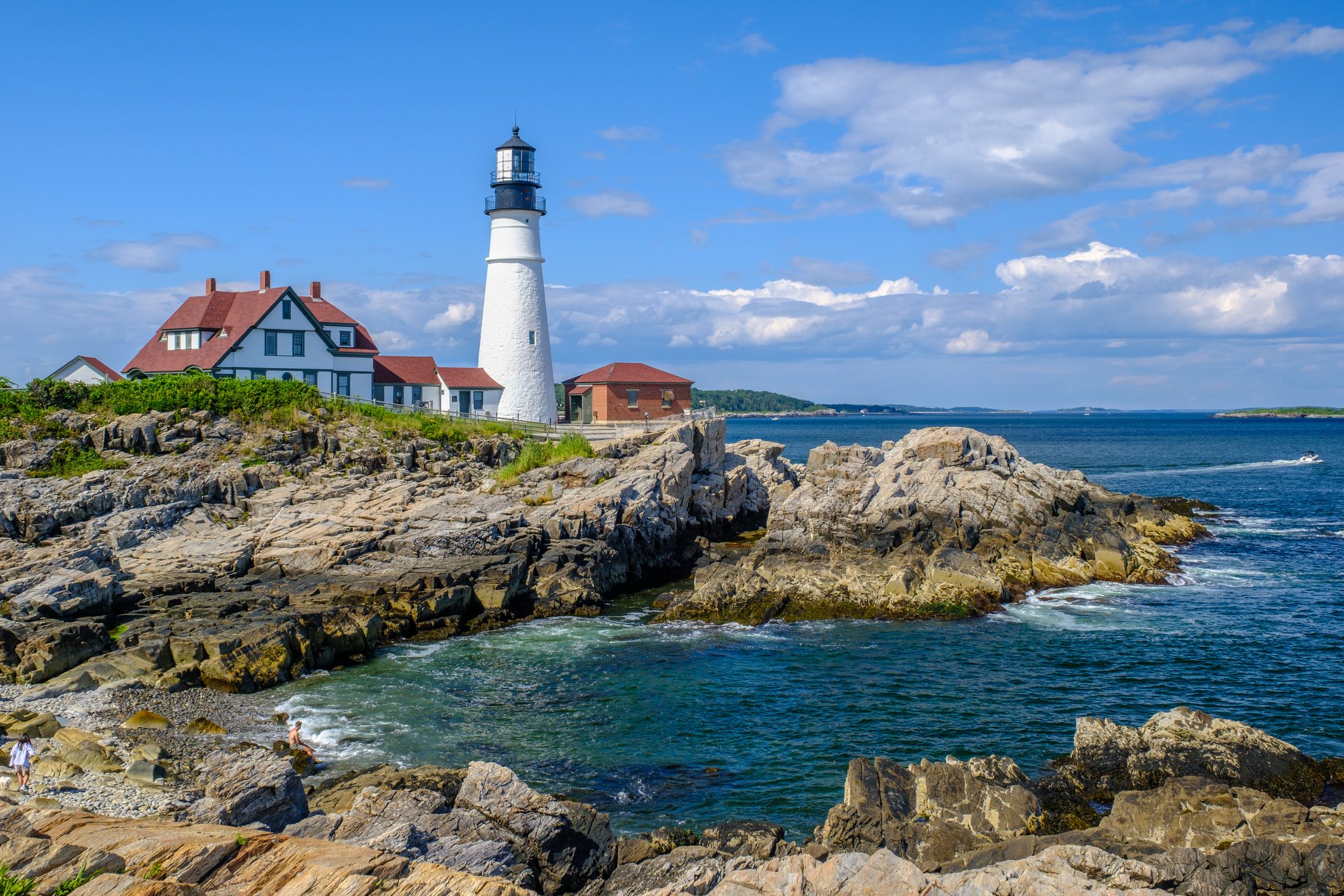 Lighthouse on a rocky coast in summer