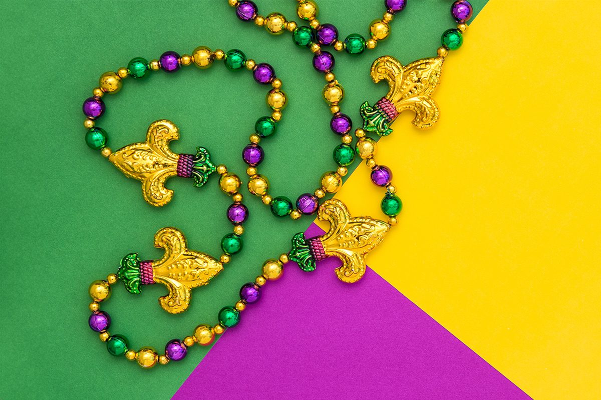 Mardi gras carnival decoration beads on yellow green purple background