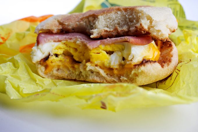 Egg McMuffin with bites taken out of it in yellow wrapping