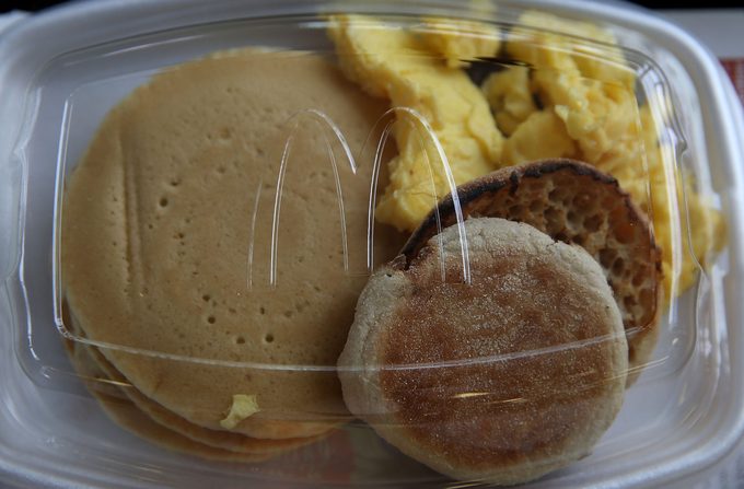 McDonald's breakfast plastic container with pancakes, english muffin, and scrambled eggs